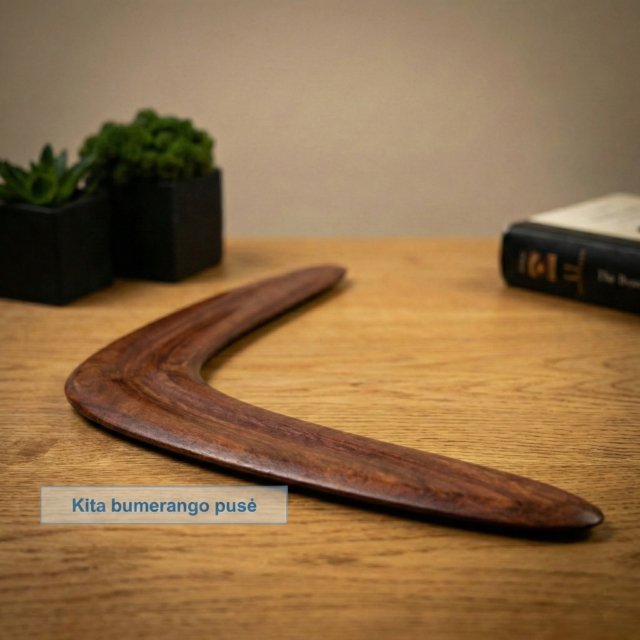 Tamsaus medžio bumerangas padėtas ant medinio stalo ofise – verslo dovanos idėja.