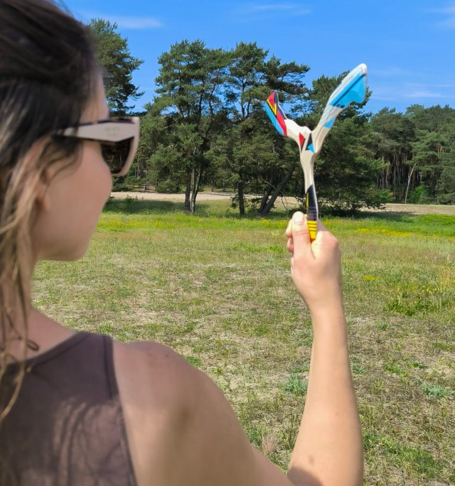 Bumerango-metimas-gamtoje-Uraganas Mergina ruošiasi mesti trišakį bumerangą „Uraganas“ miško pievelėje.