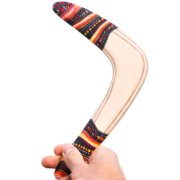 Bumerangas „Viesulas“ vyro rankoje baltame fone – matomas pilnas dizainas.